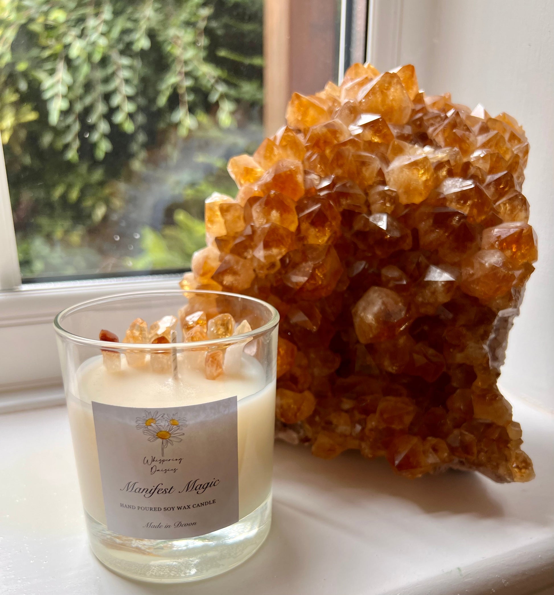 Manifest Magic Candle in a clear glass jar, topped with citrine crystal chips, handmade sherbet lemon soy candle by Whispering Daisies.