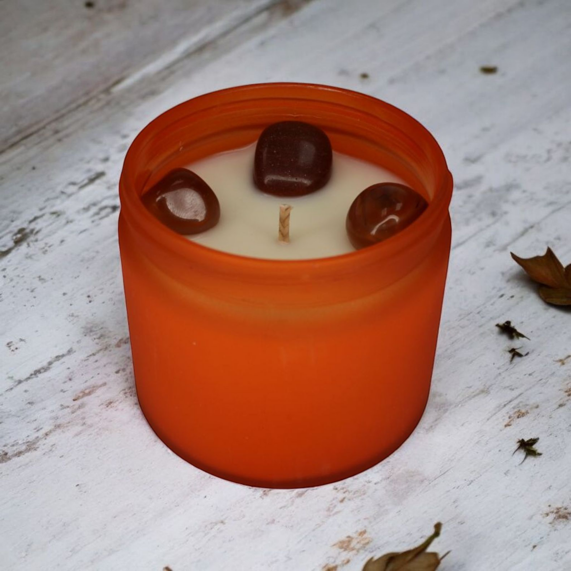 Inspiration Candle with carnelian and goldstone crystals, spicy citrus aroma, handcrafted by Whispering Daisies.