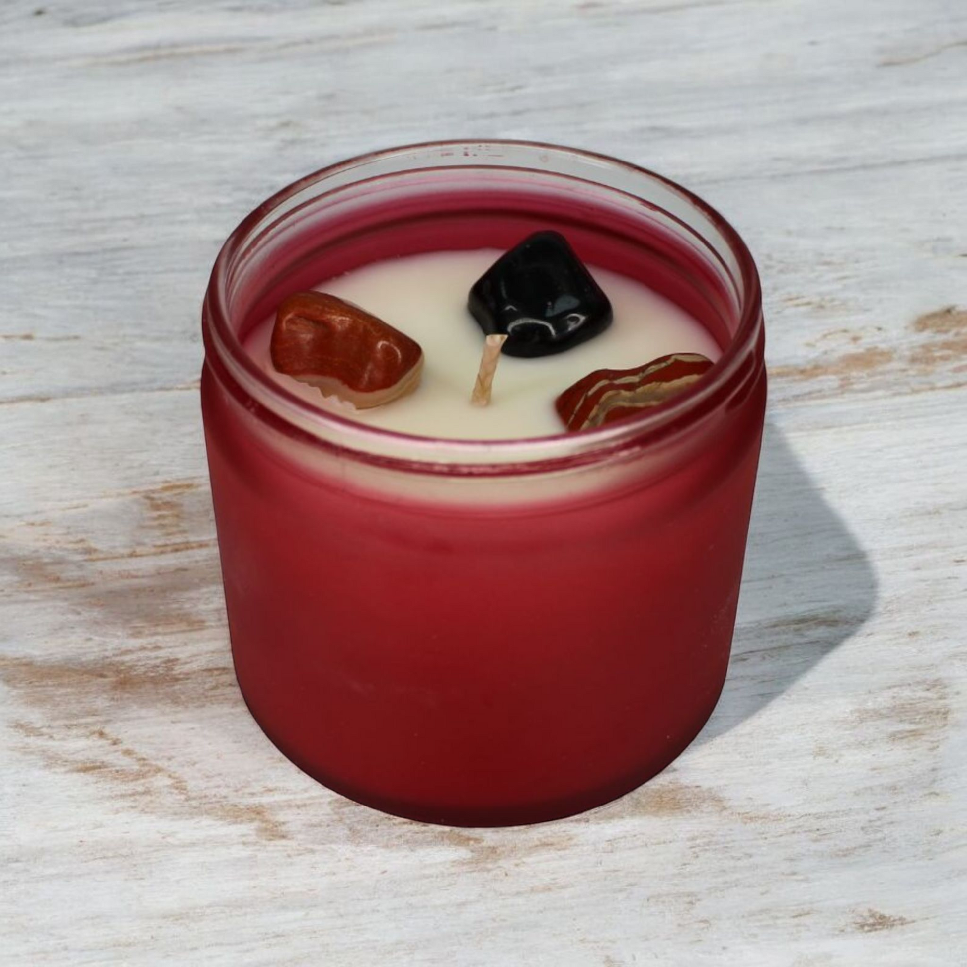 Strength Candle with black onyx and red and white jasper crystals, citrus and woody scent, handmade by Whispering Daisies.