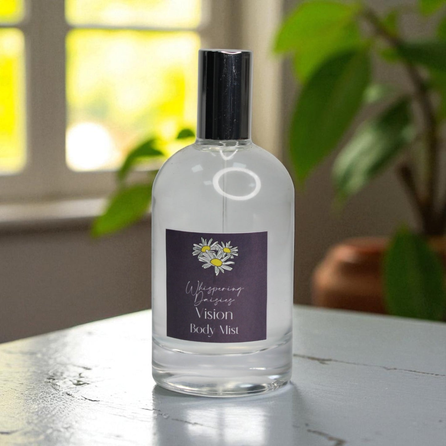 Clear bottle of 'Vision Body Mist' with a purple label on a wooden surface.